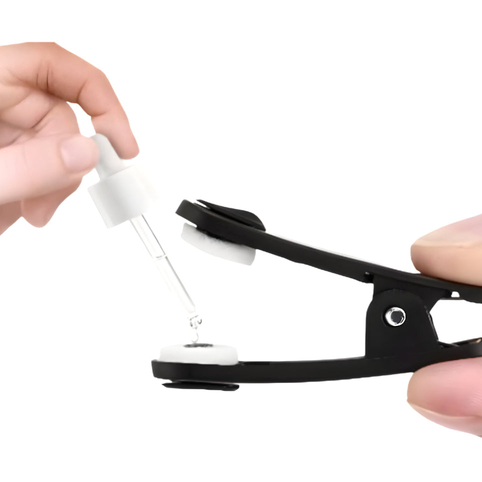 NeuroRest-Person using a dropper to add liquid into a black and white device on a white background